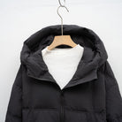 Kapuzendetail des langen Damen Steppmantels in Schwarz