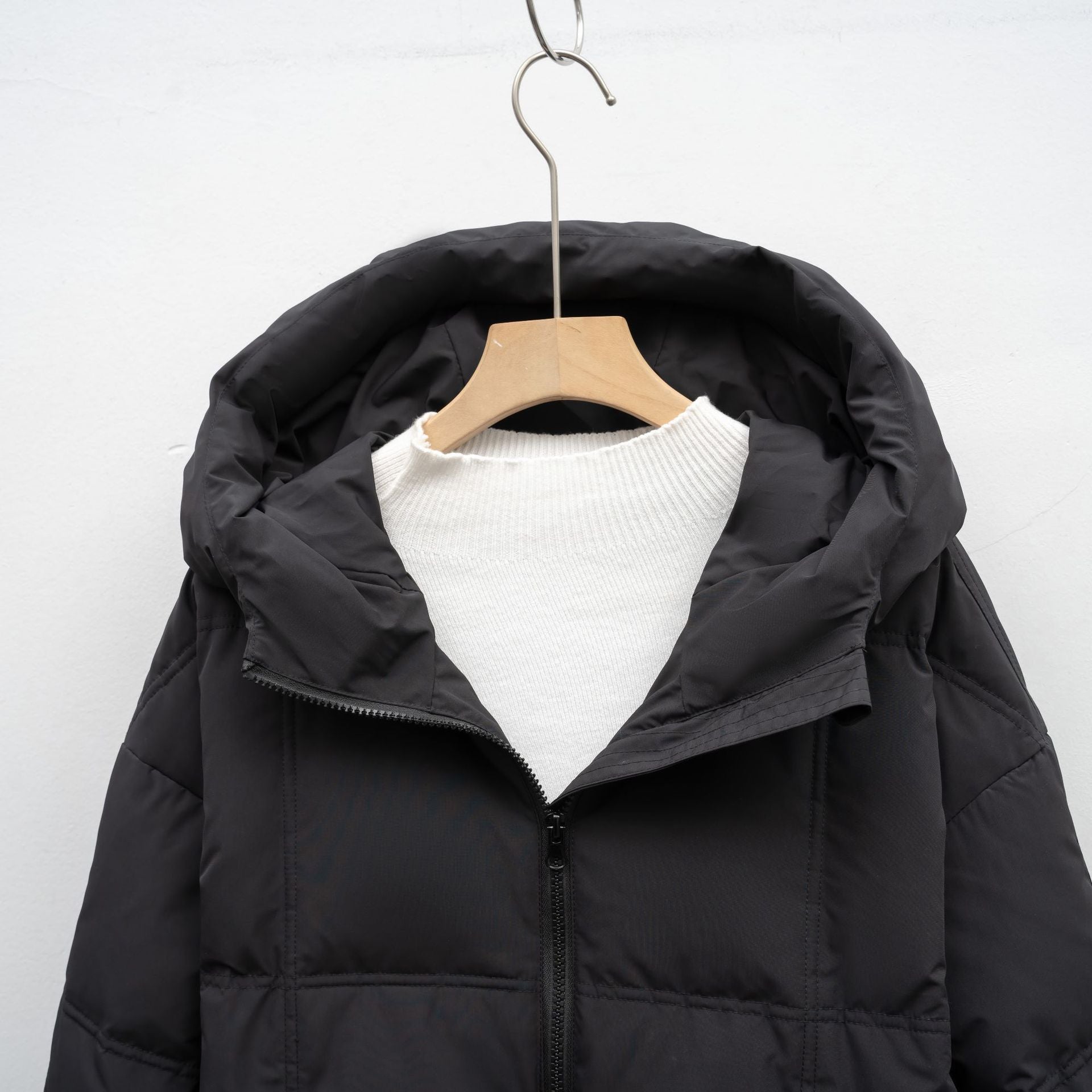 Kapuzendetail des langen Damen Steppmantels in Schwarz