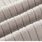 Nahaufnahme der gerippten Strickstruktur des hellgrauen Herrenpullovers